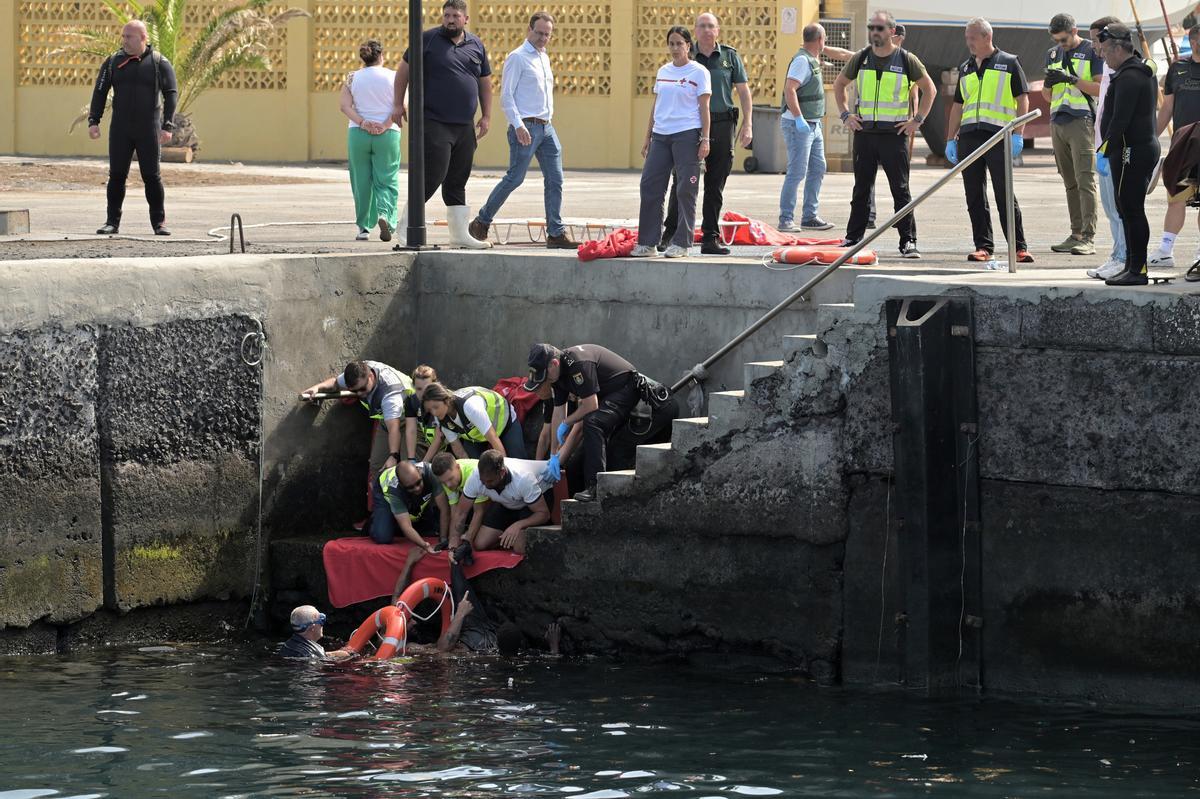 Agentes de Policía Nacional rescatan a uno de los migrantes que viajaba en el cayuco que ha volcado a su llegada al puerto de La Restinga a 28 de mayo de 2025