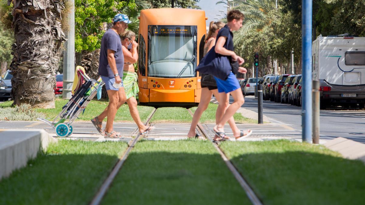 Cuatro peatones cruzan las vías del TRAM en la Playa de San Juan.