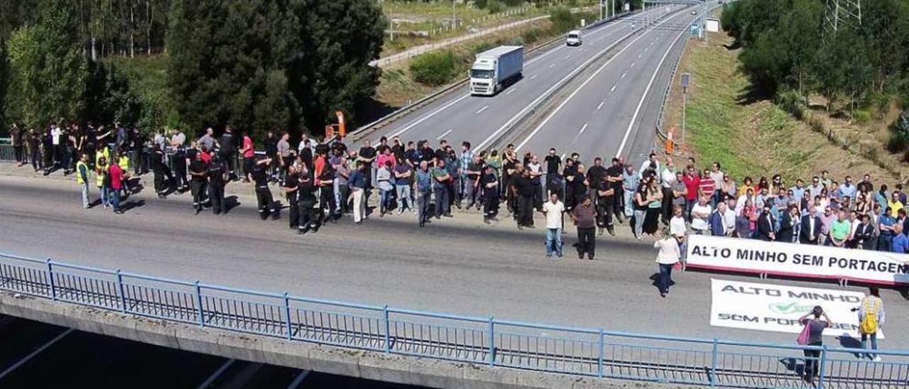 Los participantes en la protesta, ayer en una de las pasarelas sobre la A-28 en Viana. // Faro