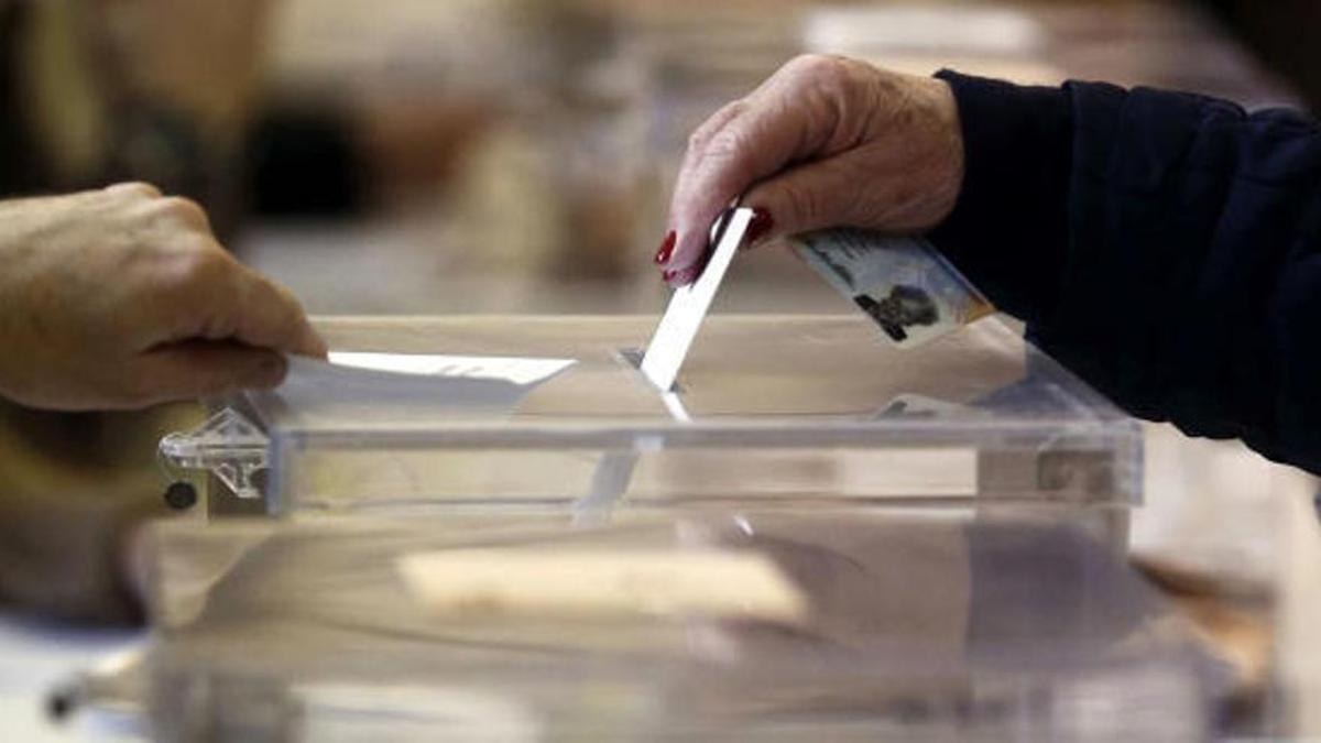 Una persona introdueix un vot en una urna