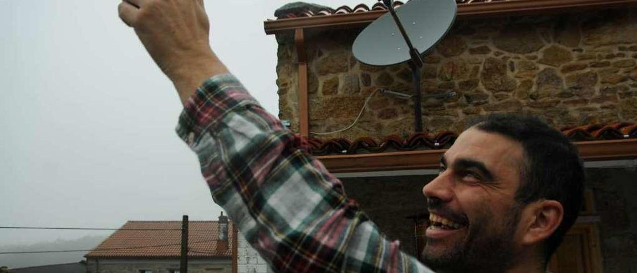 Juan Lusquiños, ayer, busca cobertura en el exterior de su hotel rural de Fofán (Meis). // Iñaki Abella