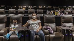 Espectadores con mascarilla, este lunes, en una sala de los Cinesa de València. 