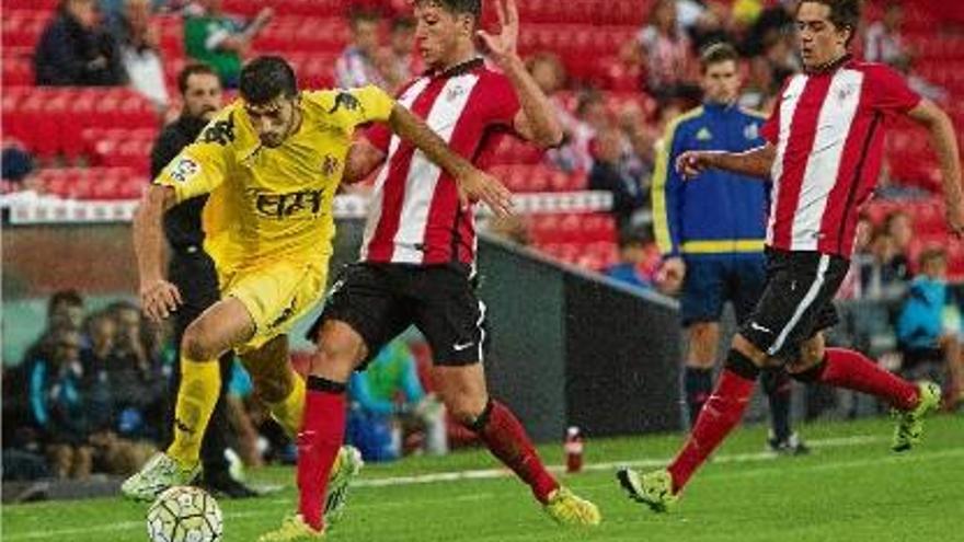 Javi Álamo s&#039;escapoleix de dos jugadors del Bilbao Ahtletic en una jugada per la banda dreta.