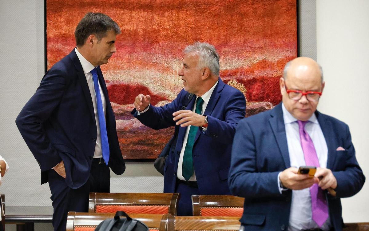 El ministro Ángel Víctor Torres (c) conversa con el conservador Fernando Enseñat en presencia del nacionalista José Miguel Barragán en junio de 2025.