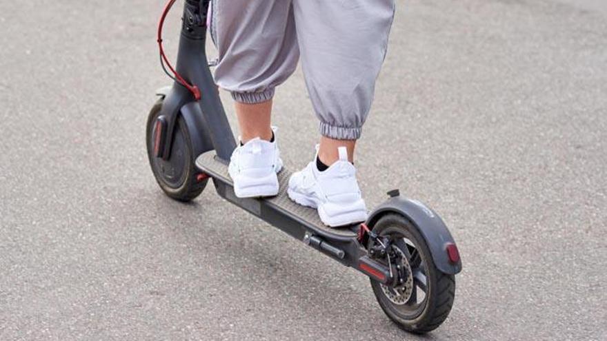 Imagen de archivo de una joven que circula en un patinete eléctrico. L.O.