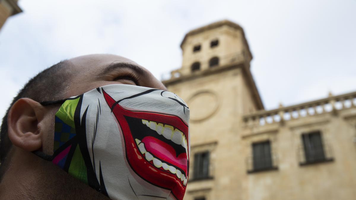 Una persona con mascarilla frente al Ayuntamiento de Alicante