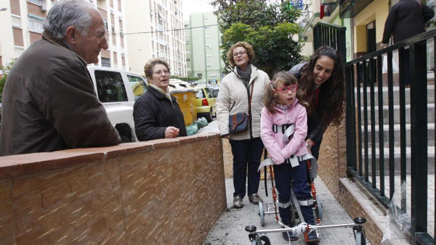 Sheila García sube con su nuevo andador ortopédico, adaptado a la perfección a su cuerpo, una rampa de su barrio de Nueva Málaga