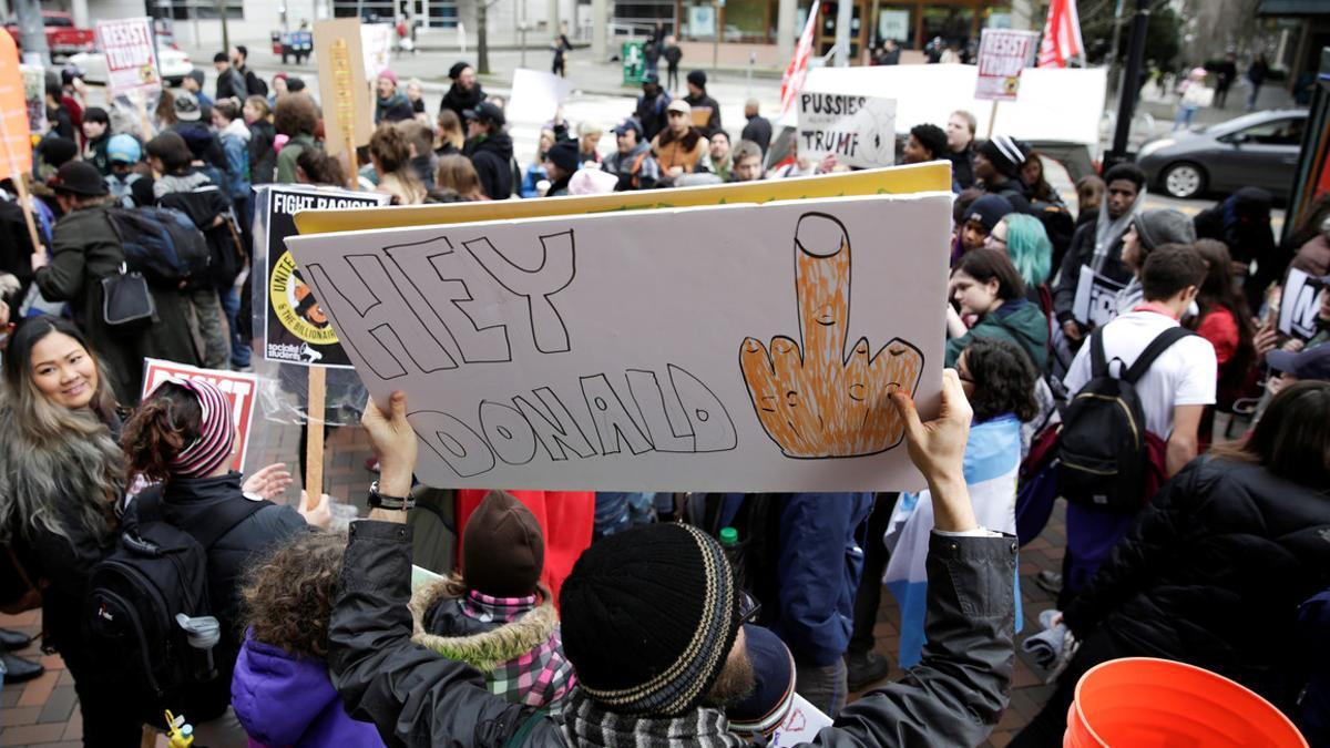 A protester holds an anti-Trump sign as students hold a walk-out in protest to U.S. President Donald Trump's inauguration in Seattle