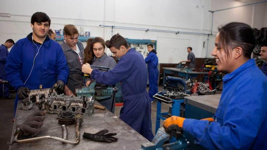 Varios estudiantes realizan prácticas en uno de los talleres de automoción.