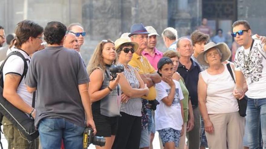 Un guía turístico ilustra a un grupo de turistas en plaza del cardenal Belluga.