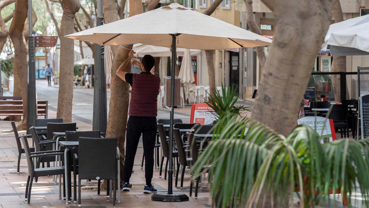 Un camarero prepara una terraza.