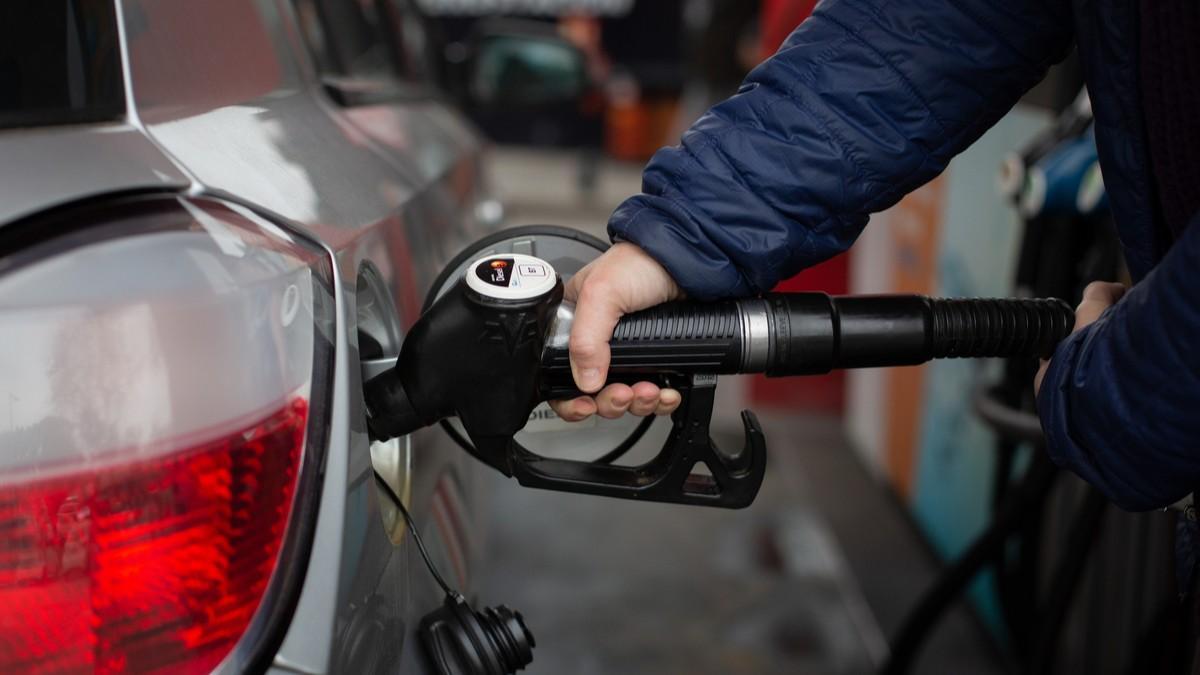 Un hombre reposta carburante diésel en una gasolinera