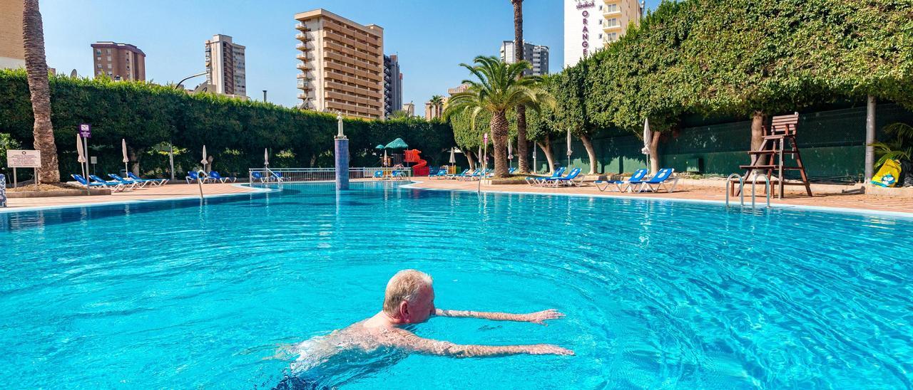 Un turista se baña en la piscina de un hotel de Benidorm, ciudad en la que solo hay abiertos siete establecimientos