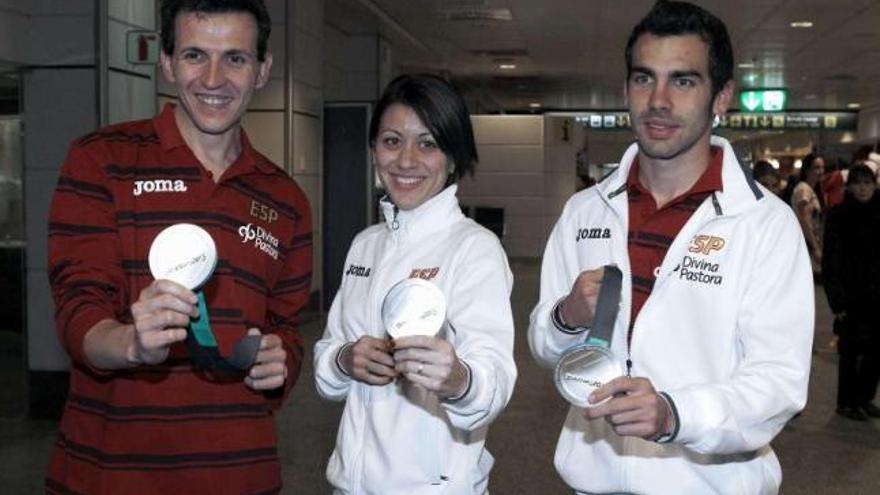 Juan Carlos Higuero, Isabel Macías y Kevin López muestran sus medallas de plata, ayer en Barajas. // Efe