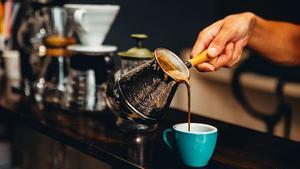 Una persona vierte el café en una taza.