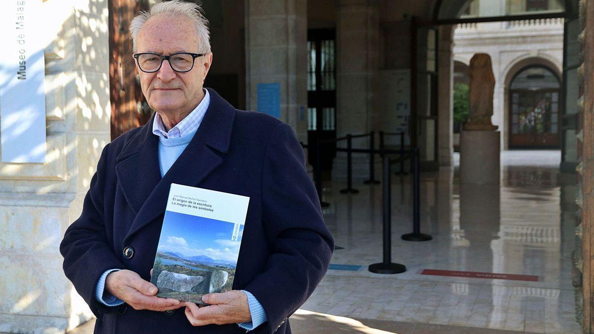 Juan Manuel Muñoz Gambero, en enero de 2021, delante del Museo de Málaga con su trabajo sobre la Escritura Lineal Megalítica (ELM), editada por la Fundación Unicaja.