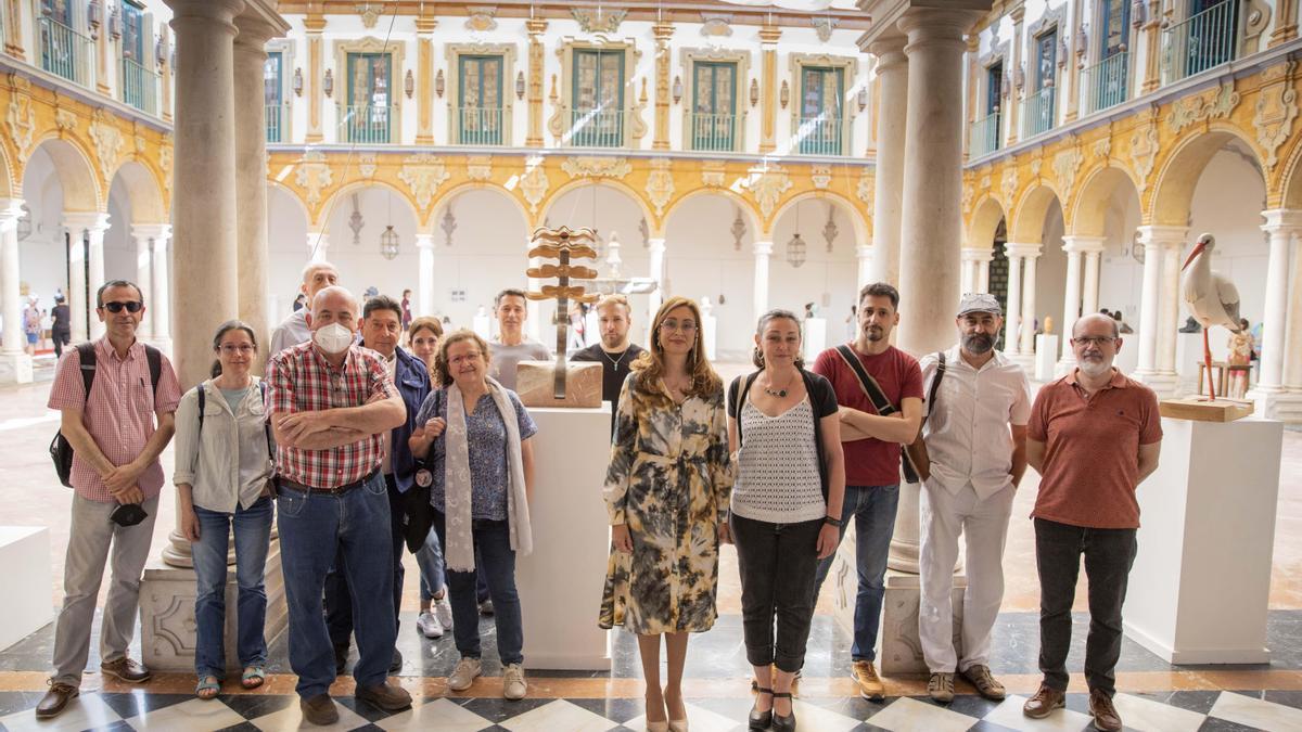 Autoridades, profesores y alumnos de la Escuela Dionisio Ortiz, ante algunas de las obras de la exposición.