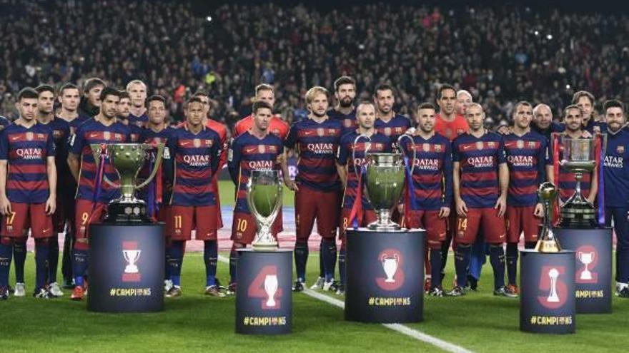 Los jugadores del Barça posan anoche antes de golear al Betis con los cinco títulos conseguidos durante 2015.