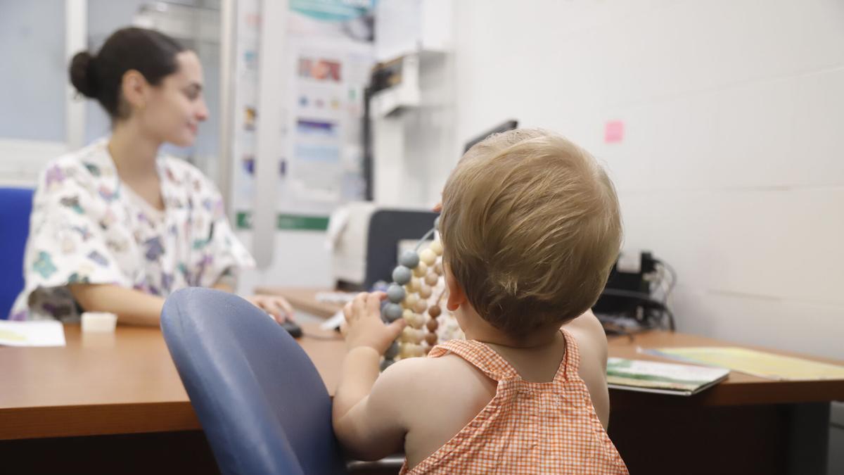 Una pediatria atiende en consulta a una madre con su bebé.
