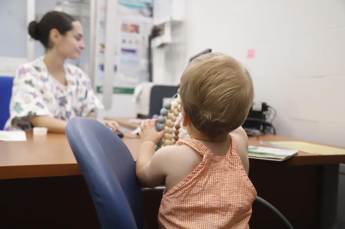 Una pediatria atiende en consulta a una madre con su bebé.