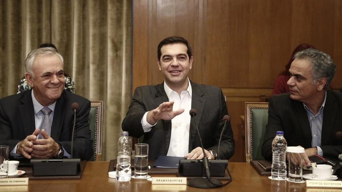 Tsipras (centro) gesticula junto al viceprimer ministro Yiannis Dragasakis (izq) y el ministro de Interior, Panagiotis Skurletis, en el consejo de ministros celebrado en el Parlamento, en Atenas, este domingo.