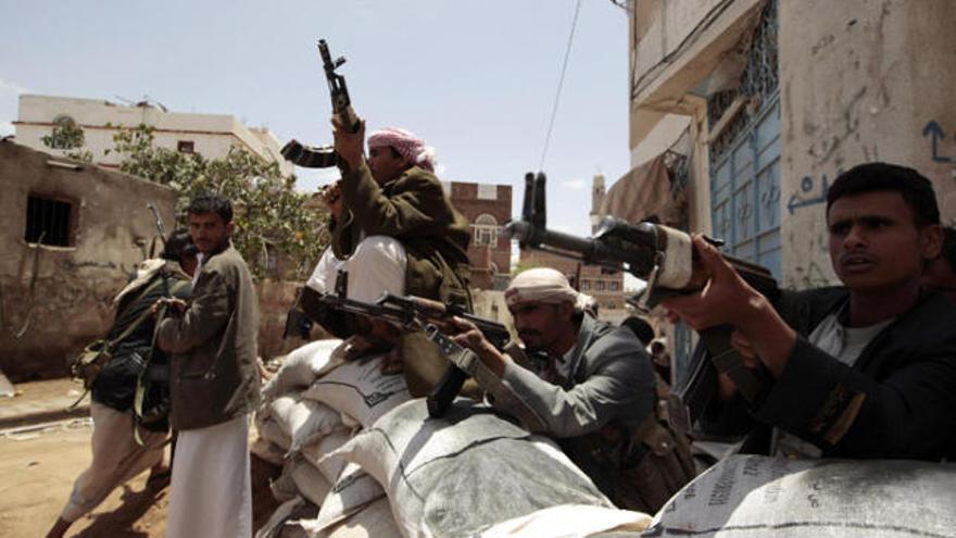 Seguidors armats del líder tribal Al-Ahmar custodien una casa.