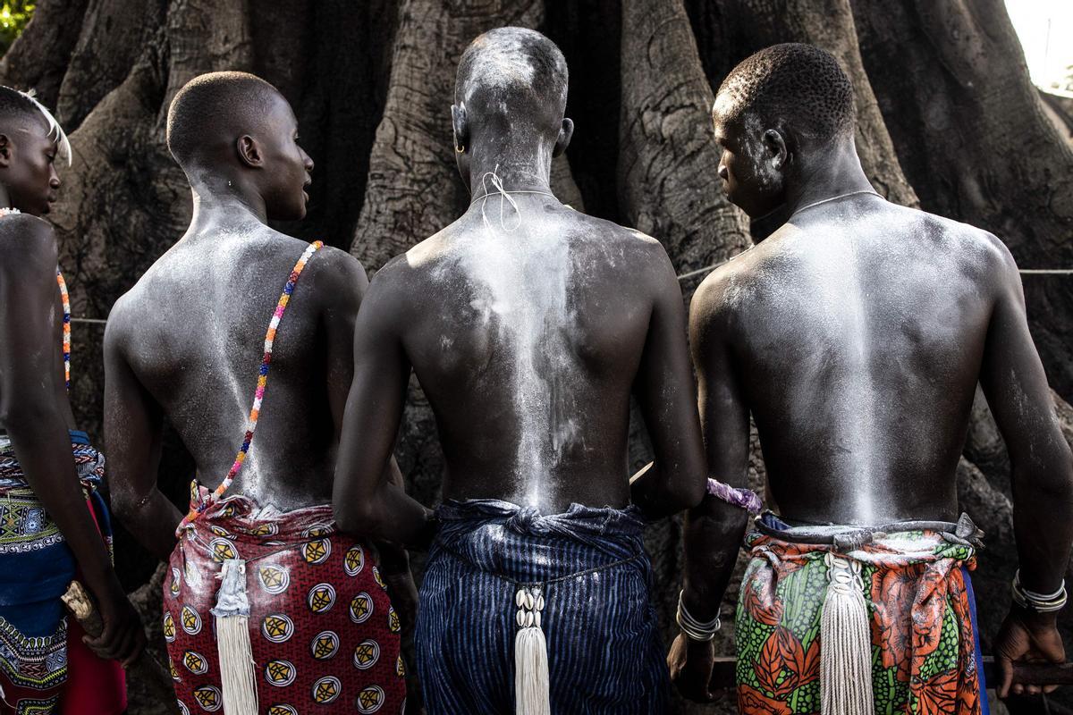 Jóvenes, vestidos con sus trajes tradicionales, asisten a una ceremonia que marca el final del proceso de iniciación anual para hombres jóvenes en Kabrousse, Senegal.