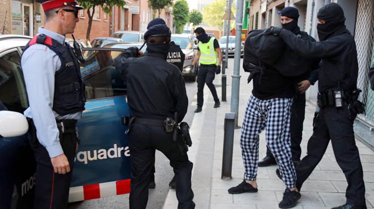 Els Mossos traslladen un dels detinguts al carrer Dolors Almeda de Cornellà.