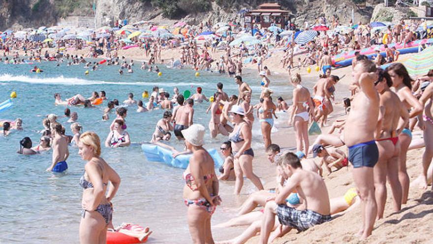 Turistes gaudint del bon temps d&#039;agost a la platja de Lloret de Mar.