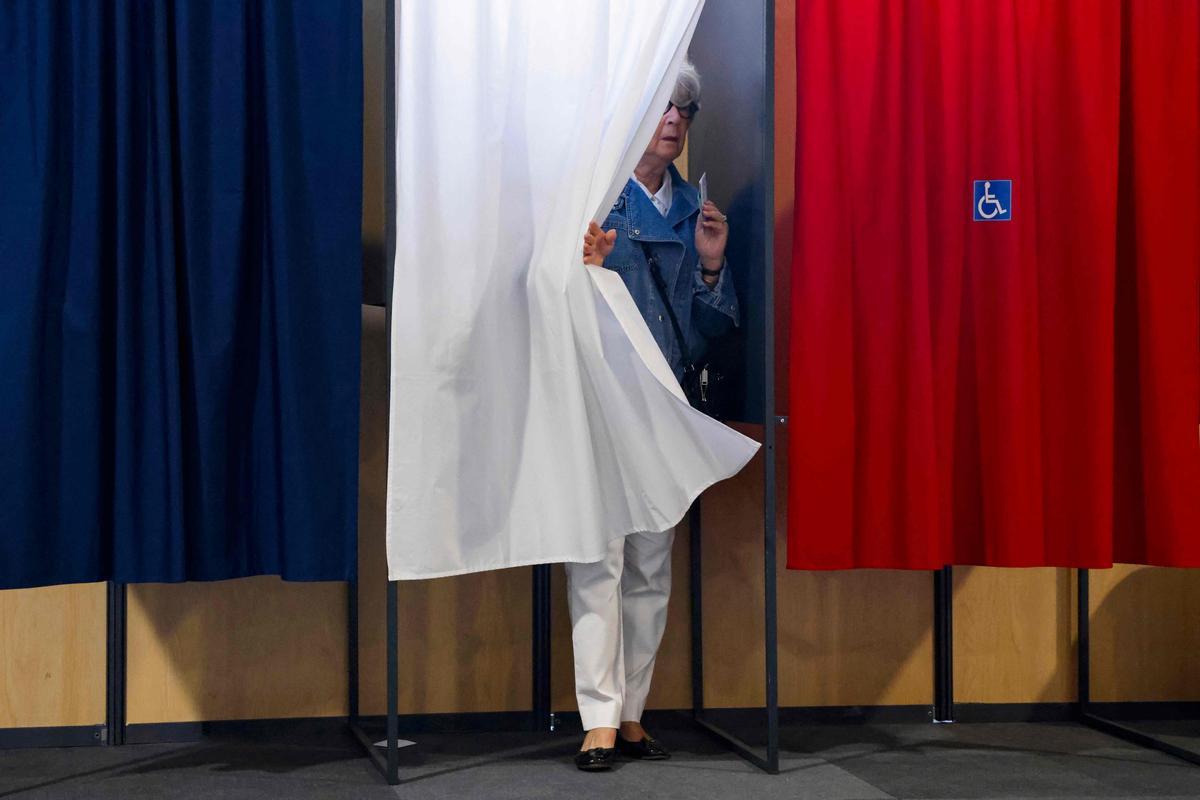 Una mujer sale con su voto de una cabina de votación en Le Touquet, en el noroeste francés.
