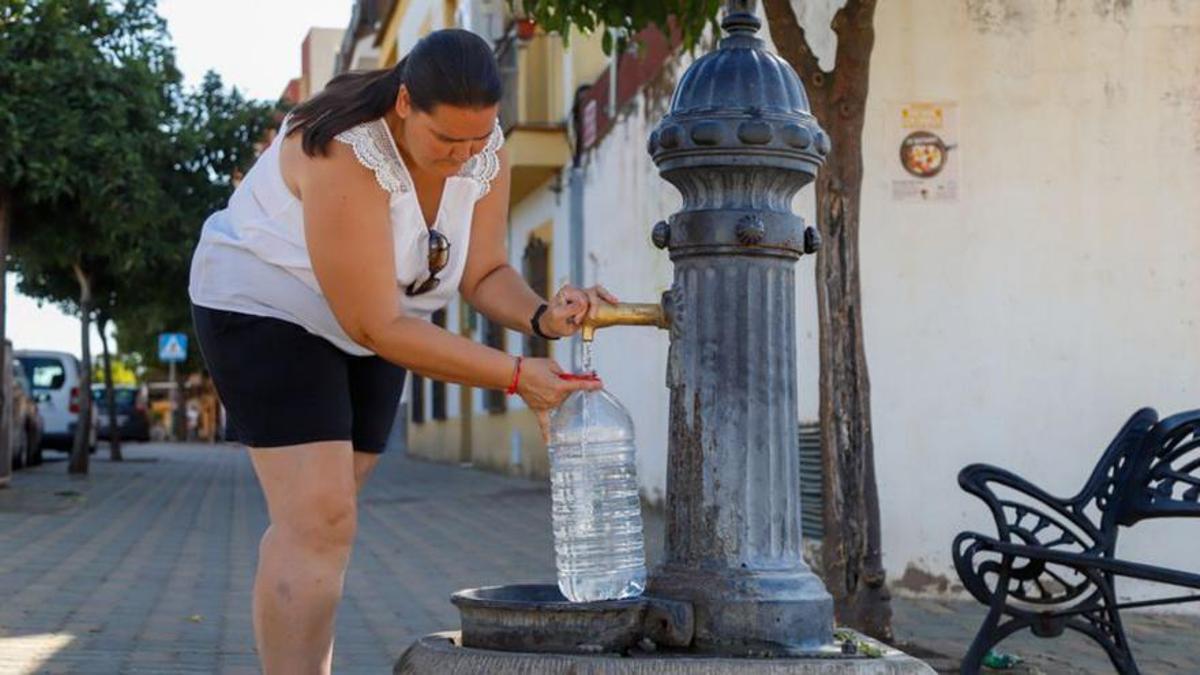 Una vecina de Alcolea llena una garrafa de agua en una fuente, el verano pasado.
