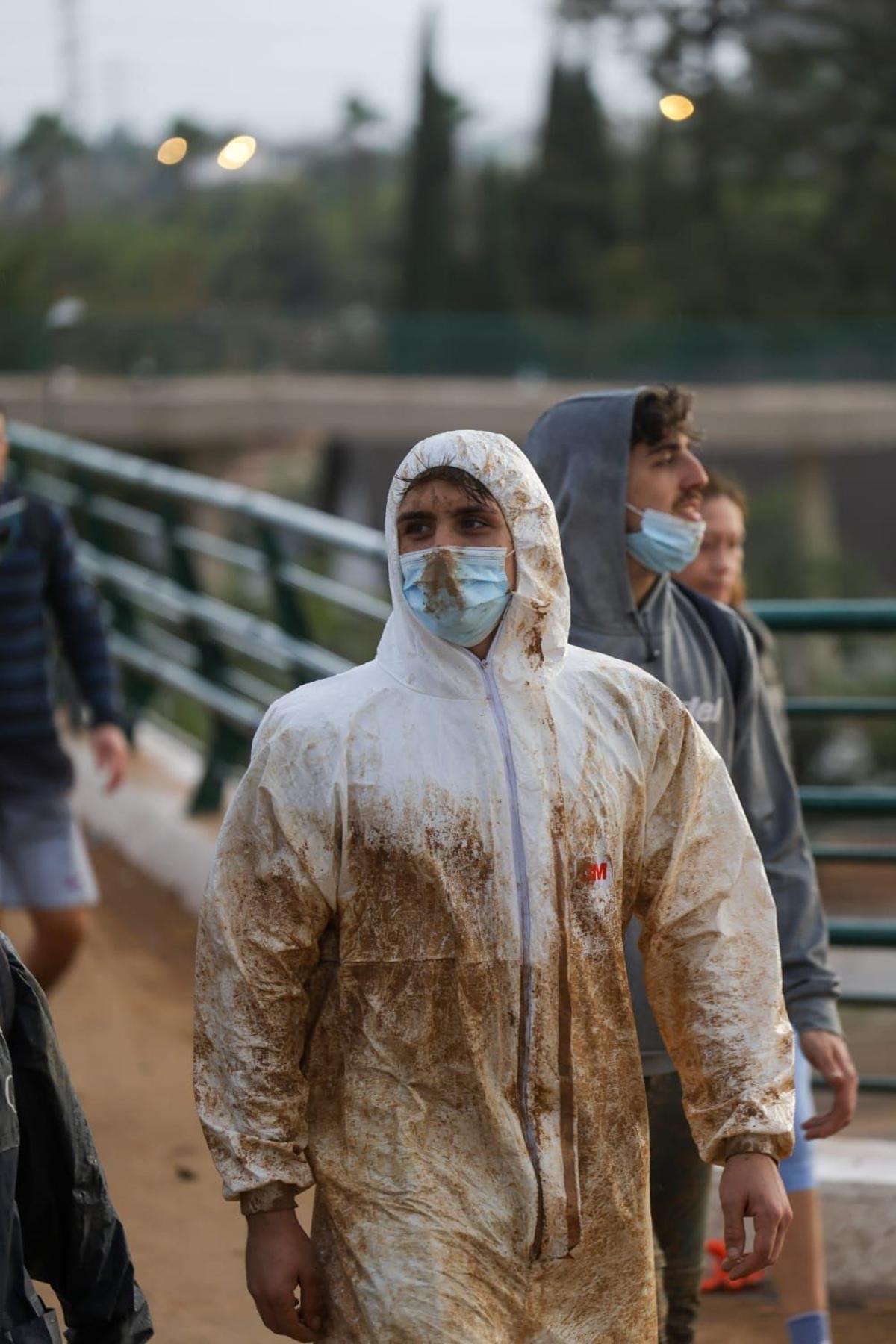 Voluntarios con monos y mascarillas en la zona de la riada.