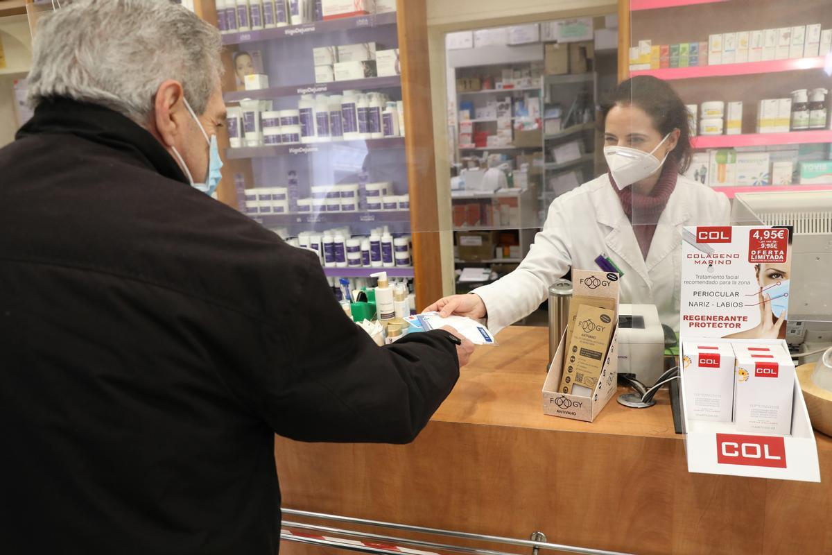 Archivo - Un anciano recoge una mascarilla FFP2 en la farmacia situada en la C/Tucán (Carabanchel), en Madrid (España), a 4 de febrero de 2021. Los mayores de 65 años de la Comunidad de Madrid pueden recoger a partir de hoy la primera de las dos mascarill
