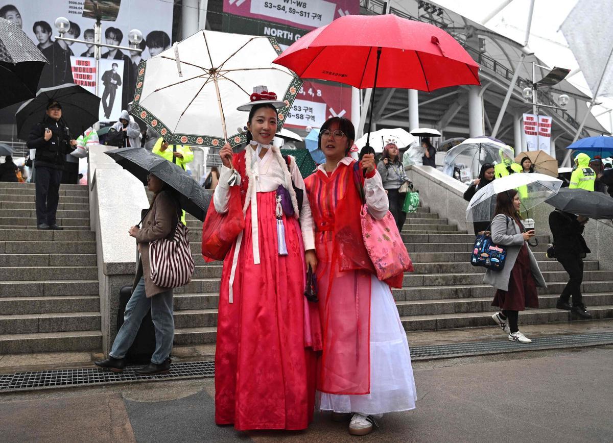 Fans de BTS, vestidos con el tradicional hanbok coreano, posan para una foto a su llegada al estadio donde la banda de K-pop BTS se presentará en Goyang el 9 de abril de 2026. Las megaestrellas surcoreanas del K-pop, BTS, dieron inicio a su gira mundial el 9 de abril, aprovechando el éxito de su álbum de regreso y una presentación histórica en el corazón de Seúl. (Foto de Jung Yeon-je / AFP)