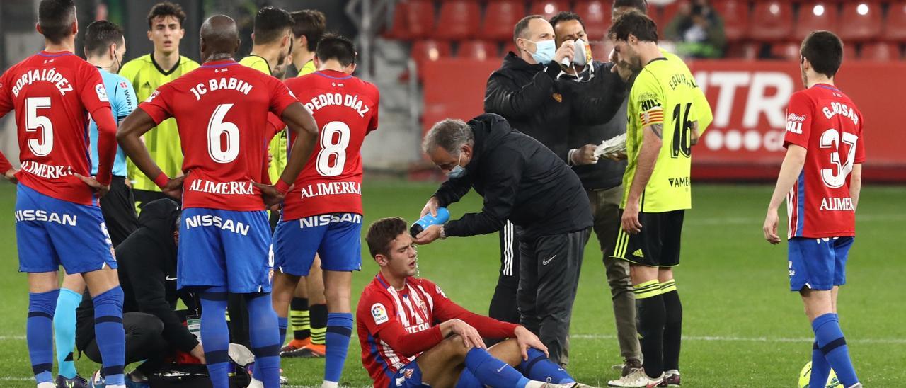 Gragera es atendido por Juan Cachero, médico del Sporting, en el partido ante el Zaragoza