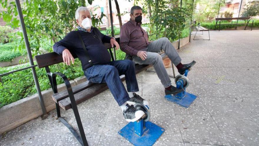 Dos hombres hacen uso de los pedales en un banco de Santa María de Gracia  | JUAN CARLOS CAVAL