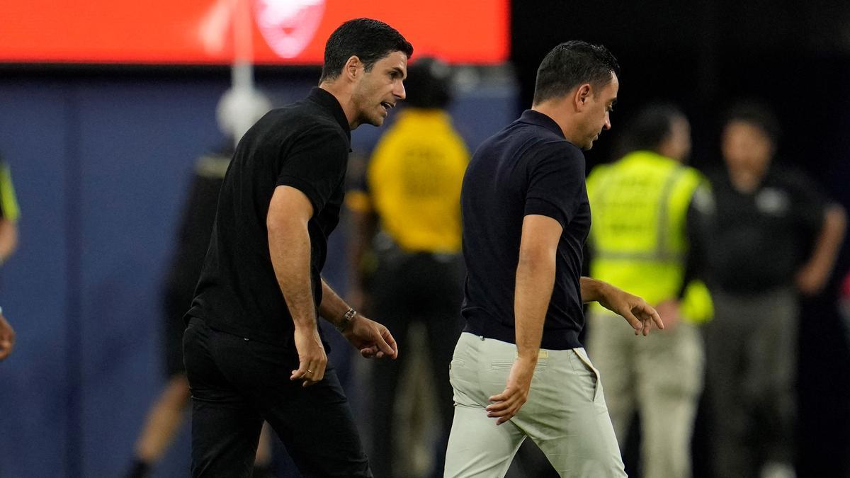 Mikel Arteta y Xavi Hernández se marchan del campo conversando.