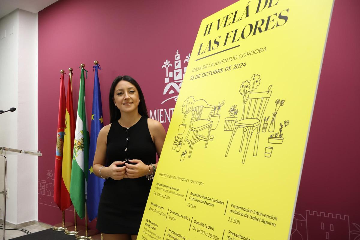 La delegada de Juventud, Cintia Bustos, junto al cartel de la segunda Velá de las Flores.