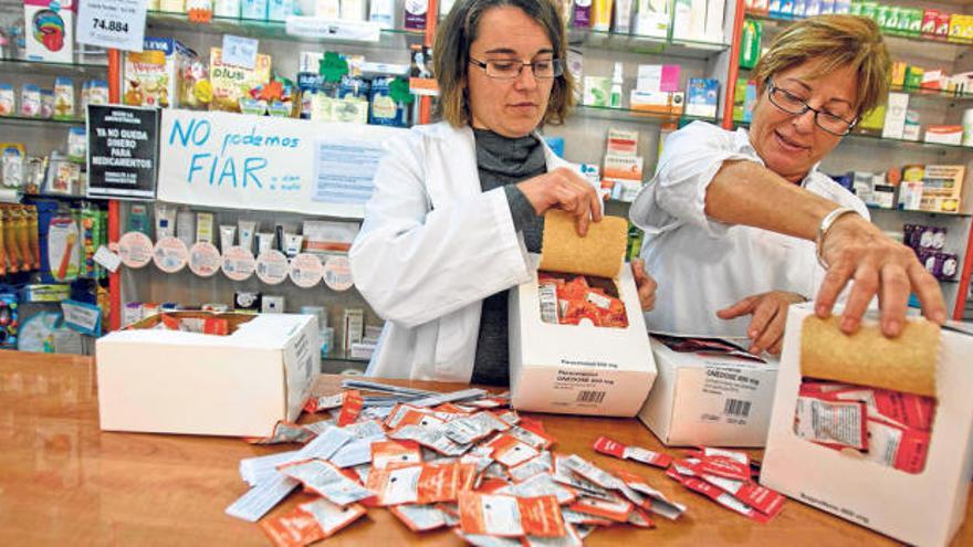 Dos farmacéuticas de Alicante muestran las cajas de unidosis que adquirieron tras su aprobación por el Ministerio y que no se llegaron a prescribir.