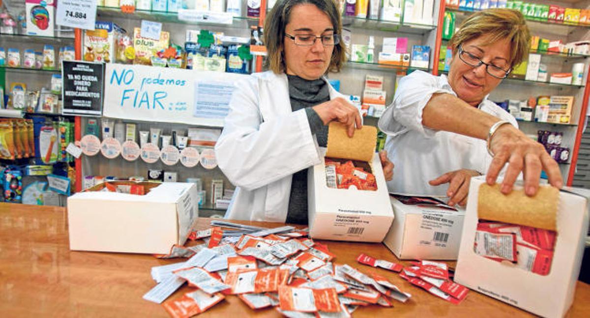 Dos farmacéuticas de Alicante muestran las cajas de unidosis que adquirieron tras su aprobación por el Ministerio y que no se llegaron a prescribir.