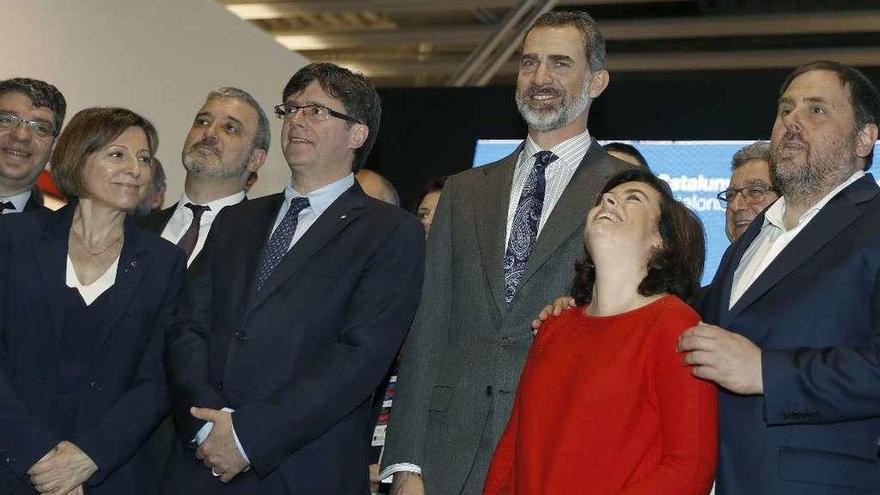 La vicepresidenta Sáenz de Santamaría y el vicepresidente catalán Junqueras (dcha.), bromean en presencia del Rey, Puigdemont y otras autoridades, ayer, en la apertura de Mobile World Congress. // Efe