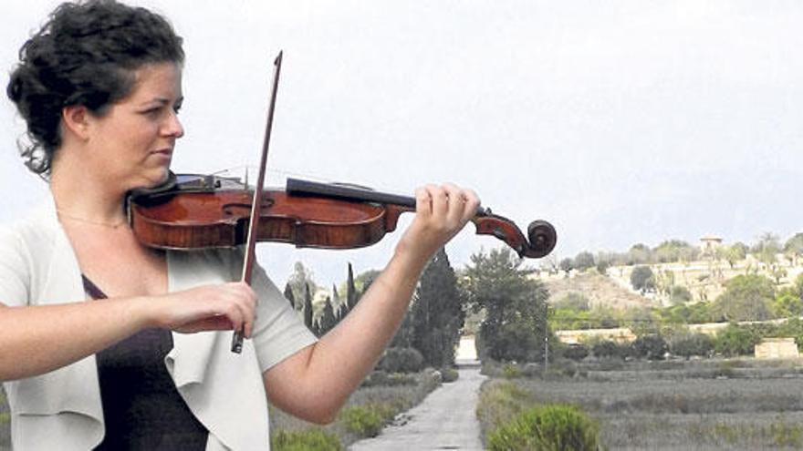 La violinista hace sonar su instrumento en las afueras de Maria de la Salut.