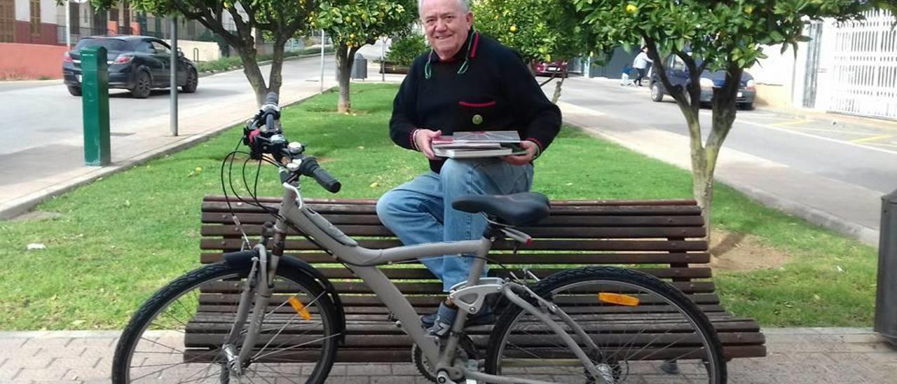 El cronista Joan Payeras posa en una céntrica plaza de sa Pobla con libros y una bicicleta.