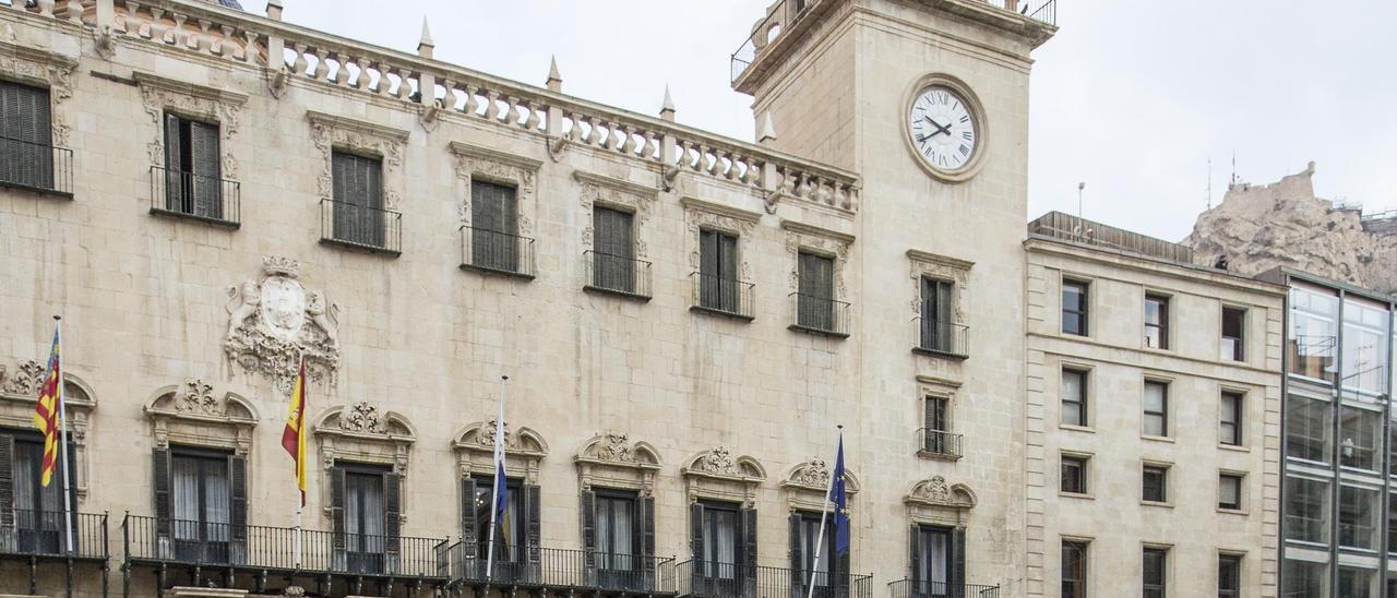 Fachada del Ayuntamiento de Alicante, reflejada en un charco