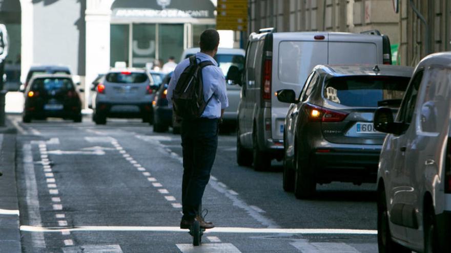 Un usuario de patinete por una calle del centro de la ciudad