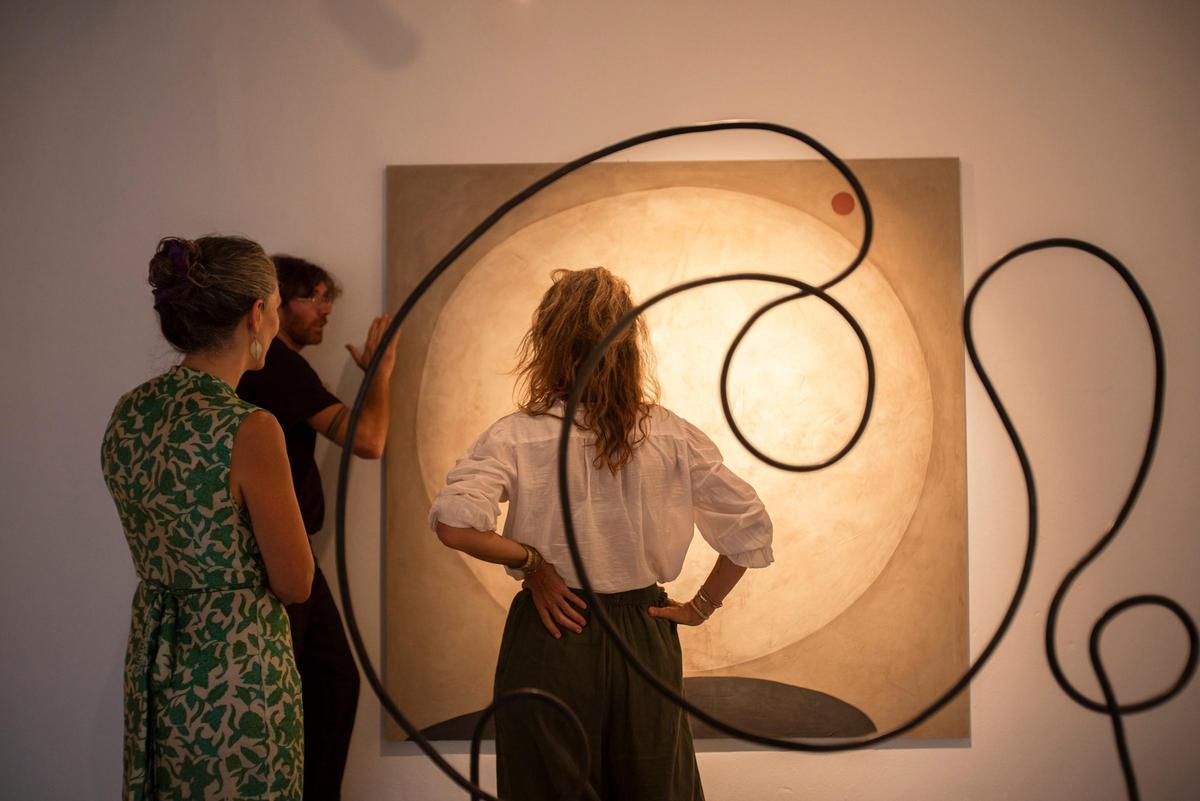 L'escultor Jaume Roig explica part de la seva obra exposada a Secret Mill a unes visitants.