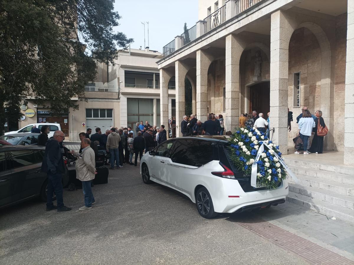El vehicle fúnebre amb la gran corona blanc-i-blava