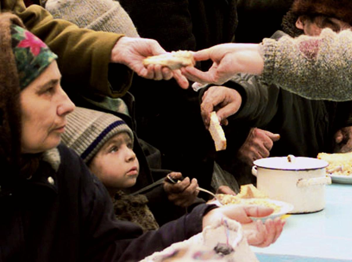 Residentes de Grozni reciben comida durante la guerra en febrero de 2000