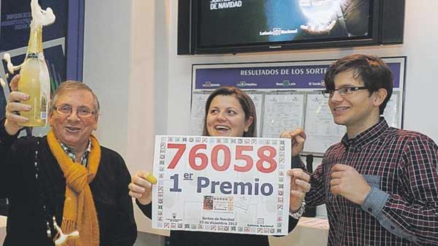 María Eirís muestra el número ganador, con su hermano, a la izquierda, y su padre