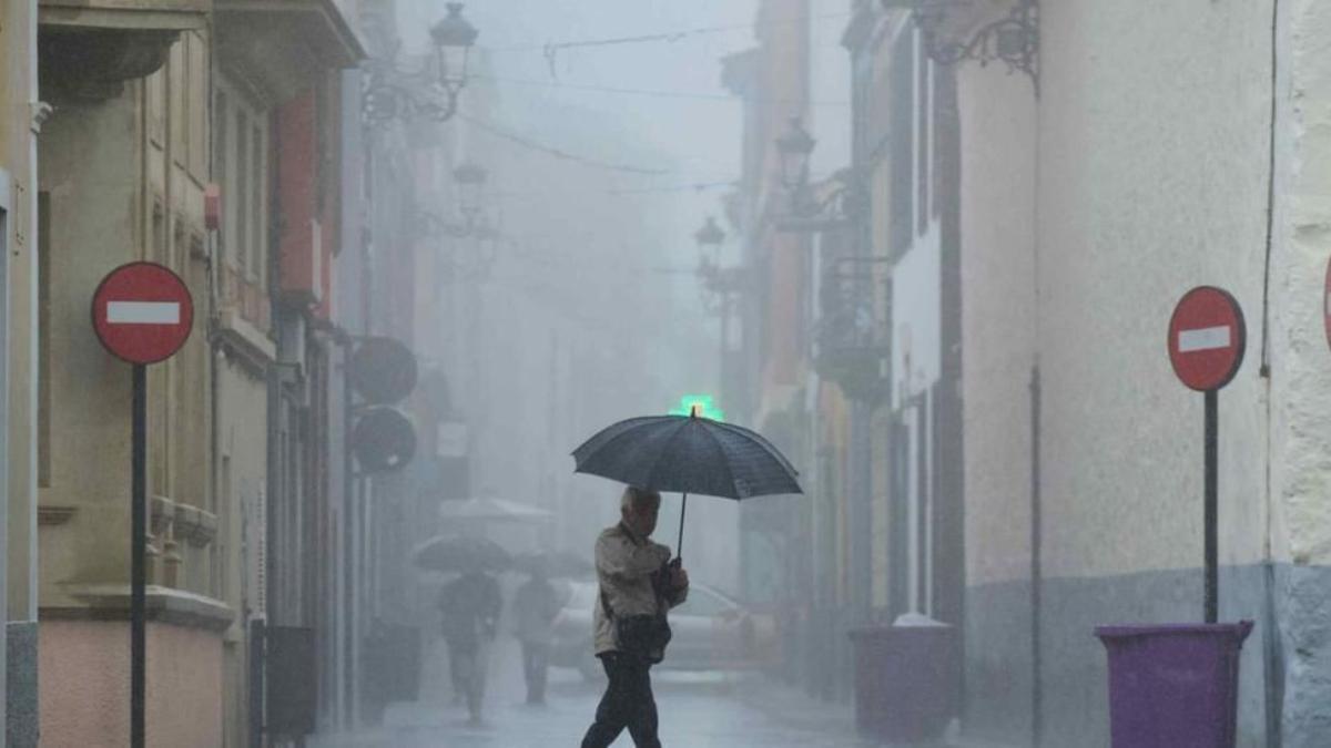 Un hombre pasea bajo la lluvia